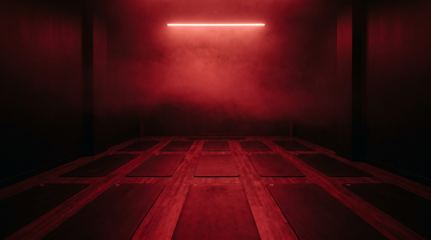 The red-lit hot mat room at Onyx with rows of mats under crimson light
