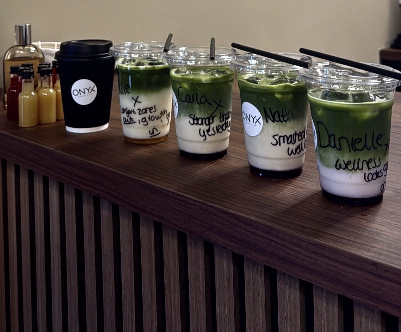 Iced matcha drinks lined up on the walnut counter of the refuel bar at Onyx Lagree and Co, Doncaster